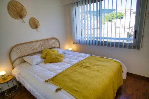 une chambre avec un lit avec une couverture jaune dessus dans l'établissement Ref MARCO - 2p Mandelieu, à Mandelieu-la-Napoule