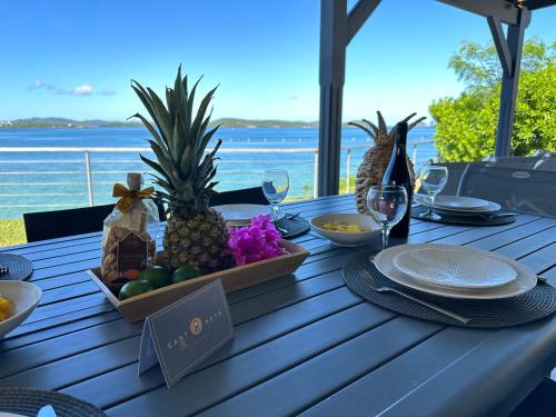 a table with a bowl of fruit and wine glasses at EAST KEYS - Lucy's Bay in Hyacinthe