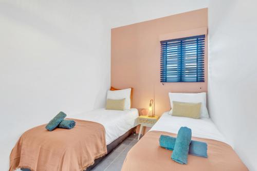 2 camas individuales en una habitación con toallas azules. en Brand new Two Bedroom Apartment at the Water, en Kralendijk