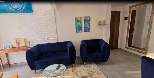 a living room with two blue chairs and a table at Dolce Vita Palacio in Douala