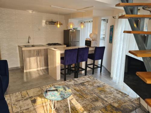 a kitchen with a table and some blue chairs at Dolce Vita Palacio in Douala