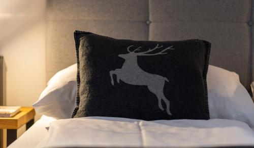a pillow with a deer on it sitting on a bed at Hotel Residenz Hochalm - Joker Card Partner in Saalbach Hinterglemm