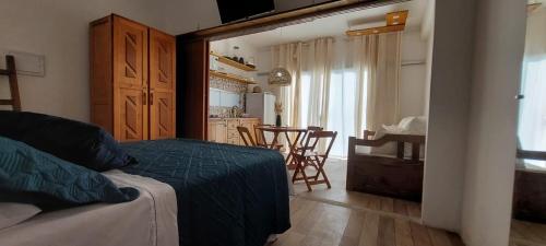 a bedroom with a bed and a kitchen with a table at Dalas Village in Marau