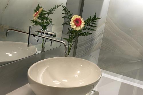 a bathroom with a sink and a vase of flowers at Hotel S. Anna in Rome