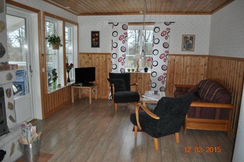 a living room with a couch and a table and chairs at Wismens Natur & Fiske in Krogsered