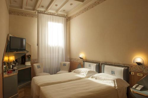 a hotel room with two beds and a television at Hotel S. Anna in Rome