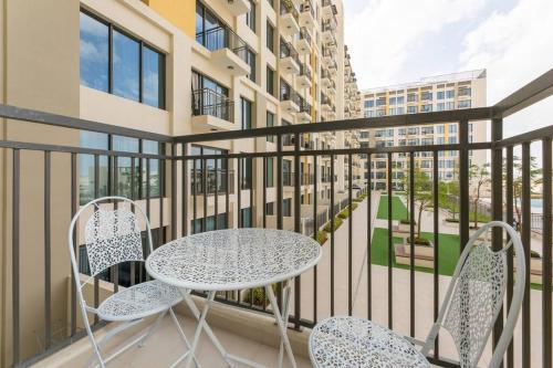 a balcony with a table and two chairs at Chic and Modern 1BR, Near Golf Course with Pool and Gym in Dubai