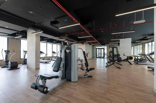 a gym with a lot of treadmills and exercise equipment at Chic and Modern 1BR, Near Golf Course with Pool and Gym in Dubai