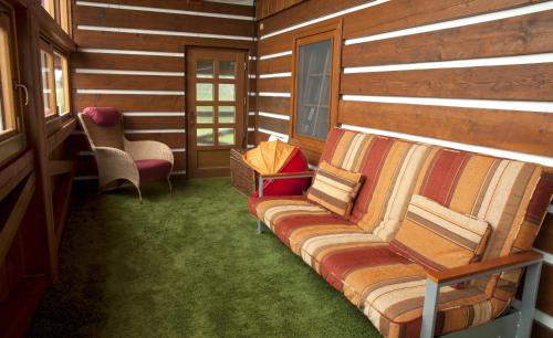 a living room with a couch and a chair at Penzion Jízdárna Hejtmánkovice in Broumov