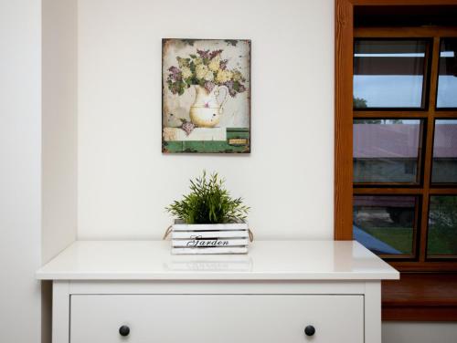 a white dresser with a painting on the wall at Penzion Jízdárna Hejtmánkovice in Broumov