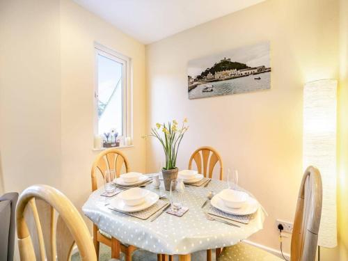 a dining room with a table with chairs and a window at Beach View - Mount Brioni in Downderry