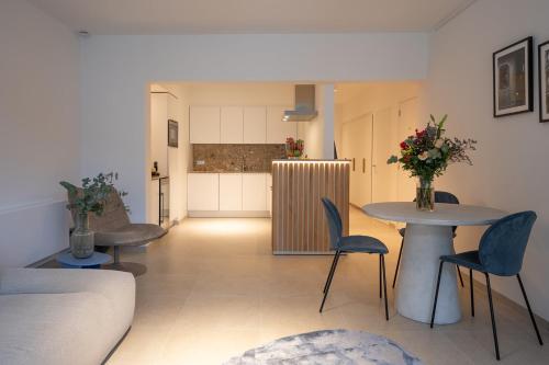 a living room with two tables and chairs and a kitchen at Snoring Bastards in Ostend