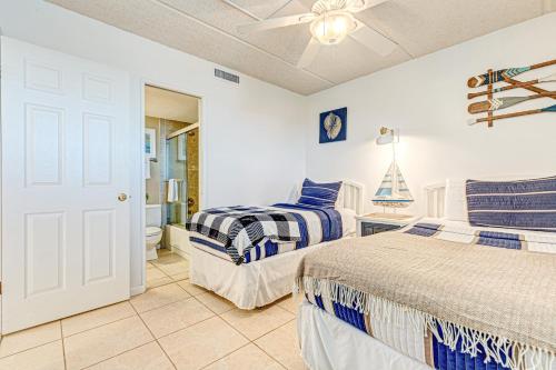 a bedroom with two beds and a ceiling fan at Southpoint #703 in Ponce Inlet