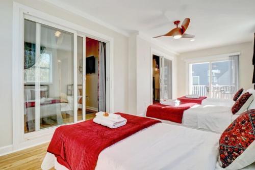 a white bedroom with two beds and a window at Bombastic Home - Steps to Beach - GameRm - Hot Tub - Pet Friendly in Surf City