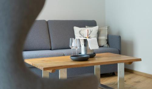a coffee table with wine glasses and a couch at Hotel Residenz Hochalm - Joker Card Partner in Saalbach Hinterglemm
