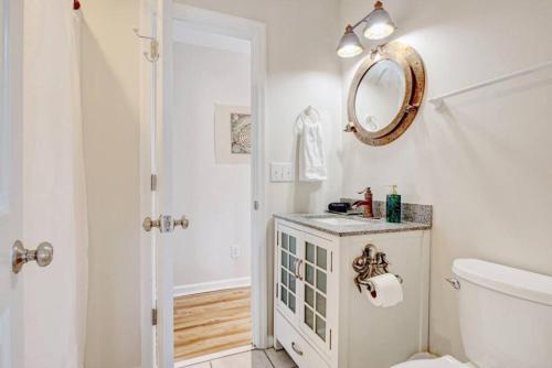 a bathroom with a toilet and a mirror on the wall at Bombastic Home - Steps to Beach - GameRm - Hot Tub - Pet Friendly in Surf City