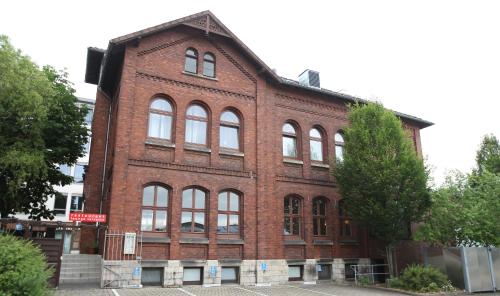 um grande edifício de tijolos vermelhos com muitas janelas em Hotel-Restaurant Entrada em Bielefeld