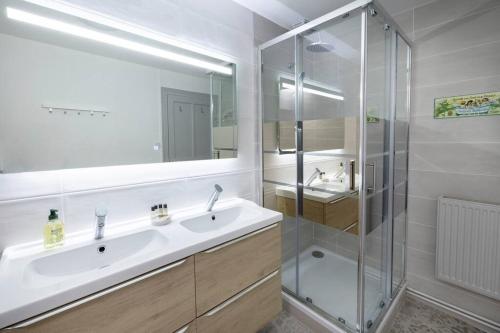 ein Badezimmer mit Waschbecken und Glasdusche in der Unterkunft Le Familial - Tout équipé - Proche centre in Montluçon