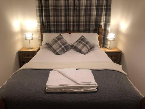 un letto con due cuscini e due asciugamani sopra di Neptune's Apartment a Fort William