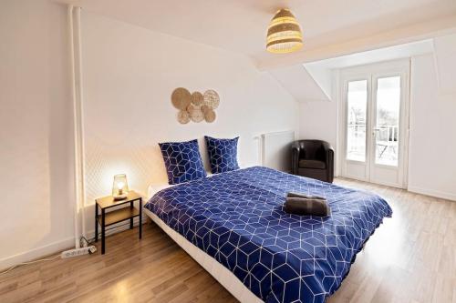 ein Schlafzimmer mit einem blauen Bett mit blauer Decke in der Unterkunft Le Familial - Tout équipé - Proche centre in Montluçon