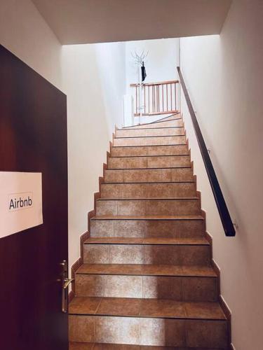 a staircase in a building with a person walking up it at Apartmán se zahradou 20 minut do centra Prahy in Ořech