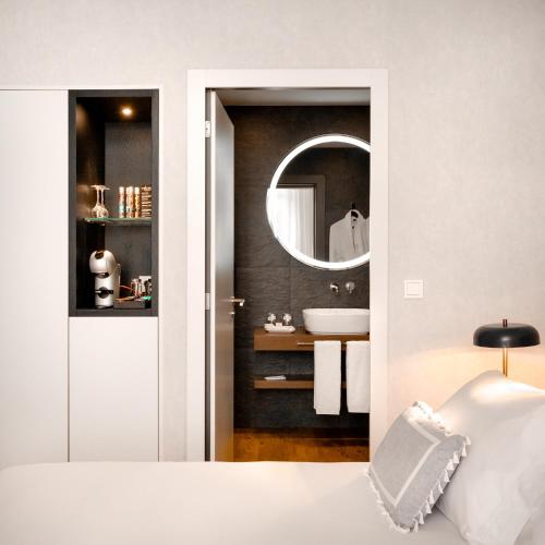 a bathroom with a sink and a mirror at MouraSuites Hotel in Évora