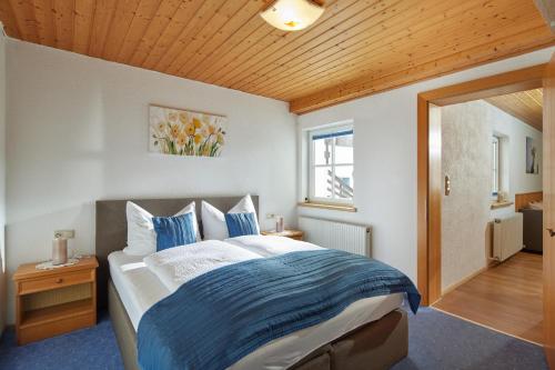 a bedroom with a bed with blue and white sheets at Haus Spettel in Gaschurn