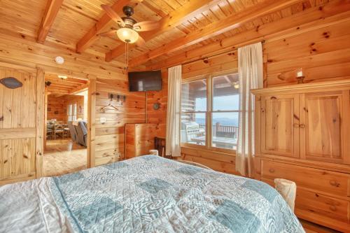 a bedroom with a bed in a room with wooden walls at Hawk's View Log Cabin in Lake Lure