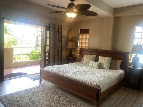 - une chambre avec un lit et un ventilateur de plafond dans l'établissement Placencia Pointe Townhomes #5, à Placencia