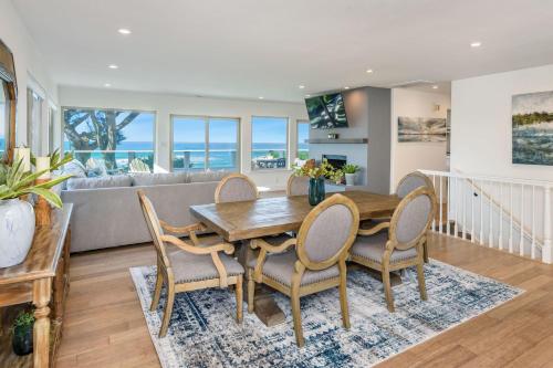 a dining room with a table and chairs and a couch at Oceanfront Home Retreat w Breathtaking Views of Fitzgerald Marine Reserve in Moss Beach