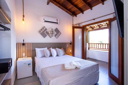 a bedroom with a bed and a balcony at Hotel Praia do Portinho in Ilhabela