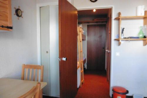 un couloir avec une porte et une chambre avec une table dans l'établissement studio à Risoul 1850 m, à Risoul