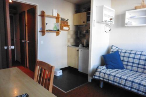 een kleine woonkamer met een bank en een tafel bij studio à Risoul 1850 m in Risoul