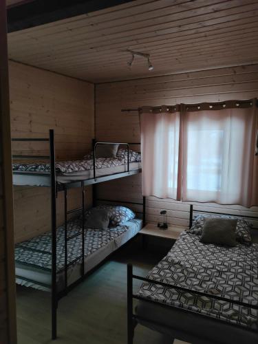 a room with two bunk beds and a window at Domki Tręby Stare in Tręby