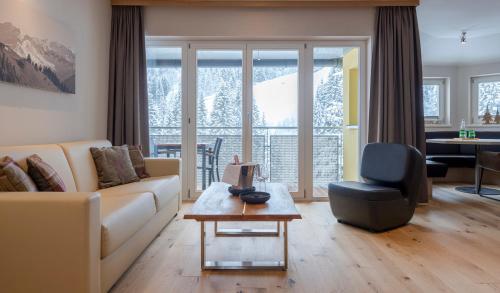 a living room with a couch and a table at Hotel Residenz Hochalm - Joker Card Partner in Saalbach Hinterglemm