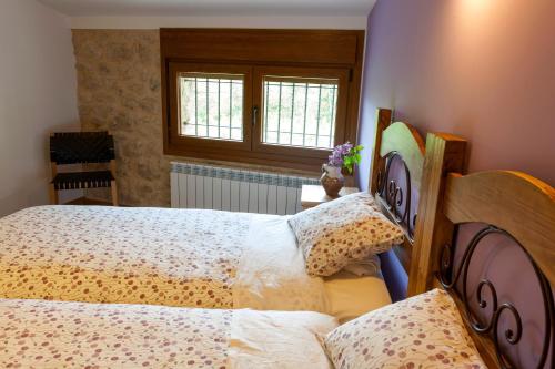 a bedroom with two beds and a window at Casa Rural Aranaratxe in Aranarache