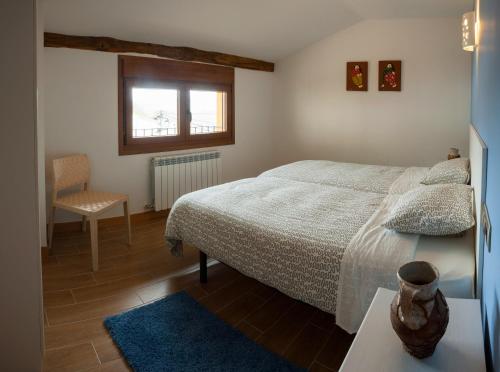 a bedroom with a bed and a chair and a window at Casa Rural Aranaratxe in Aranarache