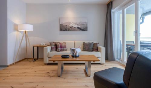 a living room with a couch and a coffee table at Hotel Residenz Hochalm - Joker Card Partner in Saalbach Hinterglemm