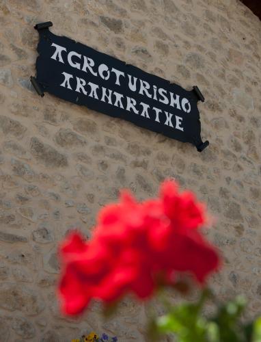 a sign on the side of a building with a red flower at Casa Rural Aranaratxe in Aranarache
