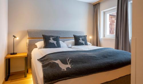 a bedroom with a bed with a blue blanket on it at Hotel Residenz Hochalm - Joker Card Partner in Saalbach Hinterglemm