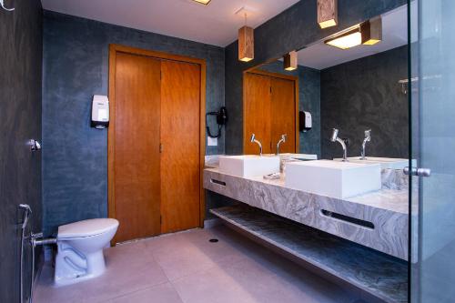 a bathroom with two sinks and a toilet at Hotel Praia do Portinho in Ilhabela