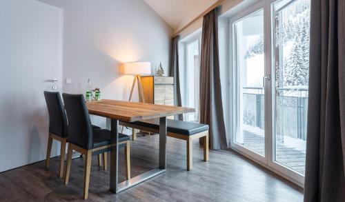 a dining room with a wooden table and black chairs at Hotel Residenz Hochalm - Joker Card Partner in Saalbach Hinterglemm