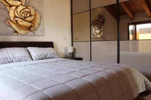 a bedroom with a large white bed with a painting on the wall at Stefano Apartments Padova Spacious,with parking in Mestrino