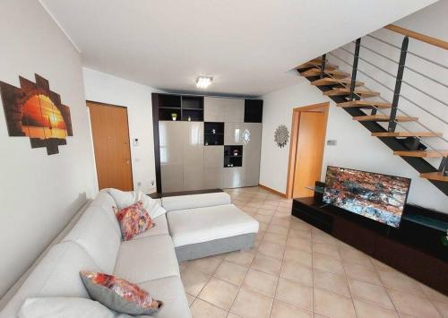 a living room with a white couch and a tv at Stefano Apartments Padova Spacious,with parking in Mestrino