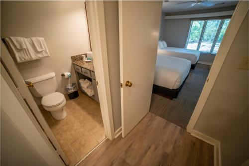a small bathroom with a toilet and a bed at Callaway Resort & Gardens in Pine Mountain