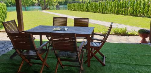 a wooden table with four chairs around it at Apartman Azul in Podastrana