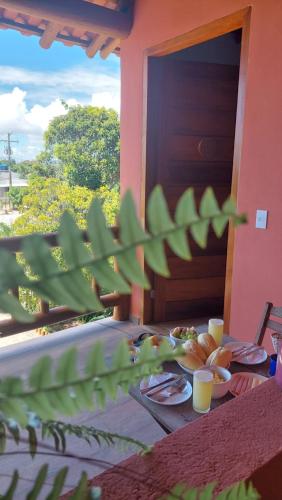 una mesa con platos de comida y vasos de jugo de naranja en Aldeia Biribiri - Pousada, en Caraíva