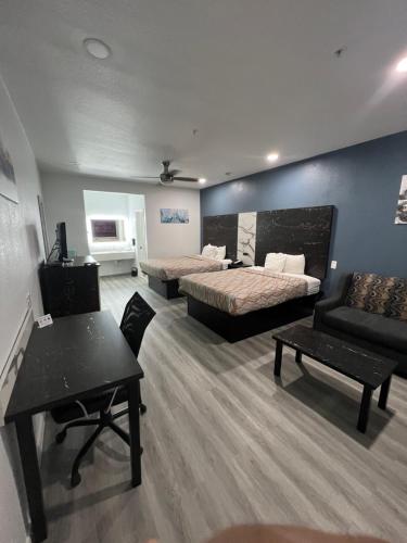 ヒューストンにあるGrand Villa Inn Galleriaのベッド2台とソファが備わるホテルルームです。