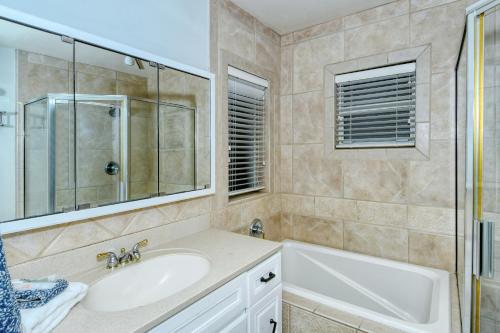 La salle de bains est pourvue d'un lavabo, d'une baignoire et d'un miroir. dans l'établissement Walk to Beach, Restaurants, Shopping/Hot Tub!, à Sarasota