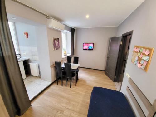 a living room with a dining room table and chairs at Like Home on Zaliznychna 3 in Ivano-Frankivsʼk